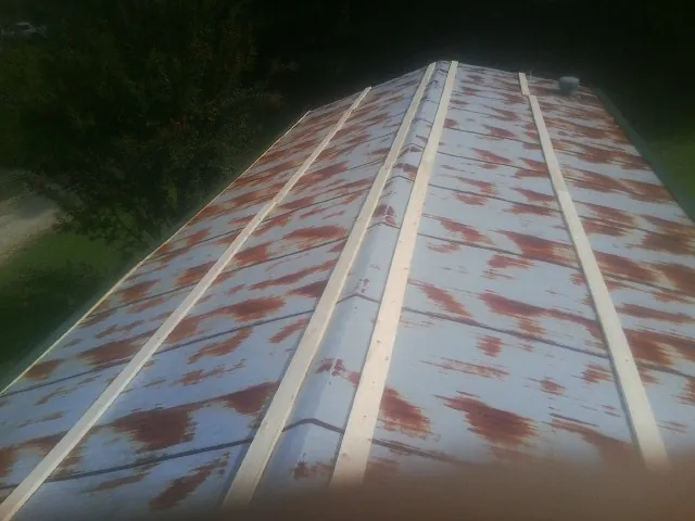 Rusted metal roof panels with new wood purlins before replacement — Storm Damage Roof Repair in Manakin Sabot by Roofing Brothers