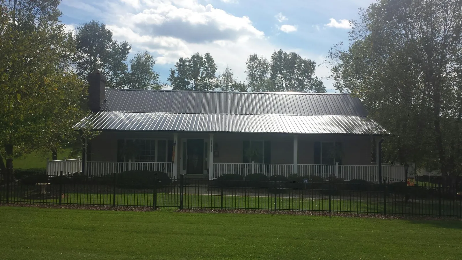 Gray metal roof on a brick ranch with a full width front porch — Gutter Guard Installation work by our crew in Manakin Sabot