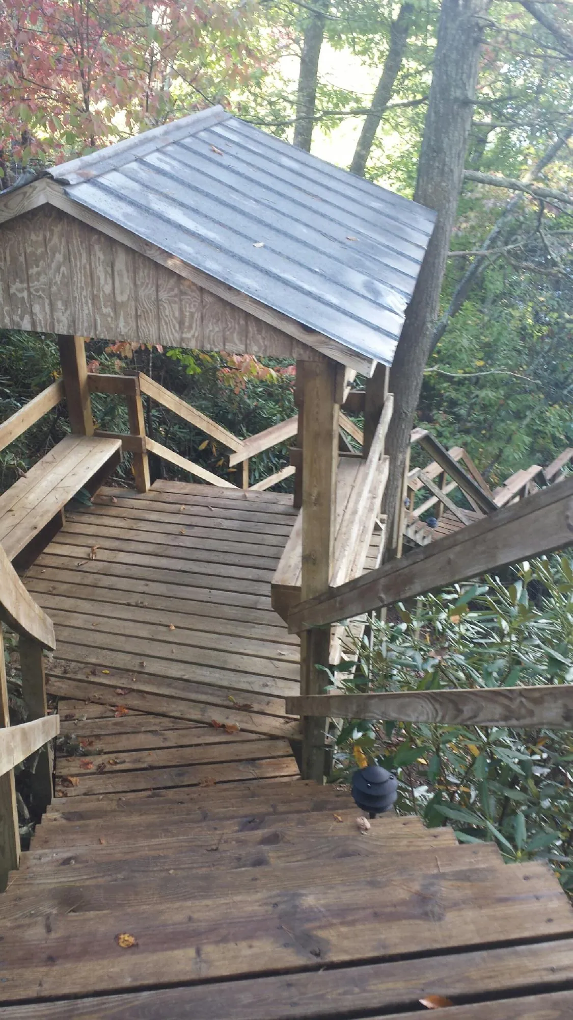 Metal roofed shelter over wooden steps on a wooded walkway — Skylight Repair & Installation work by our crew in Manakin Sabot
