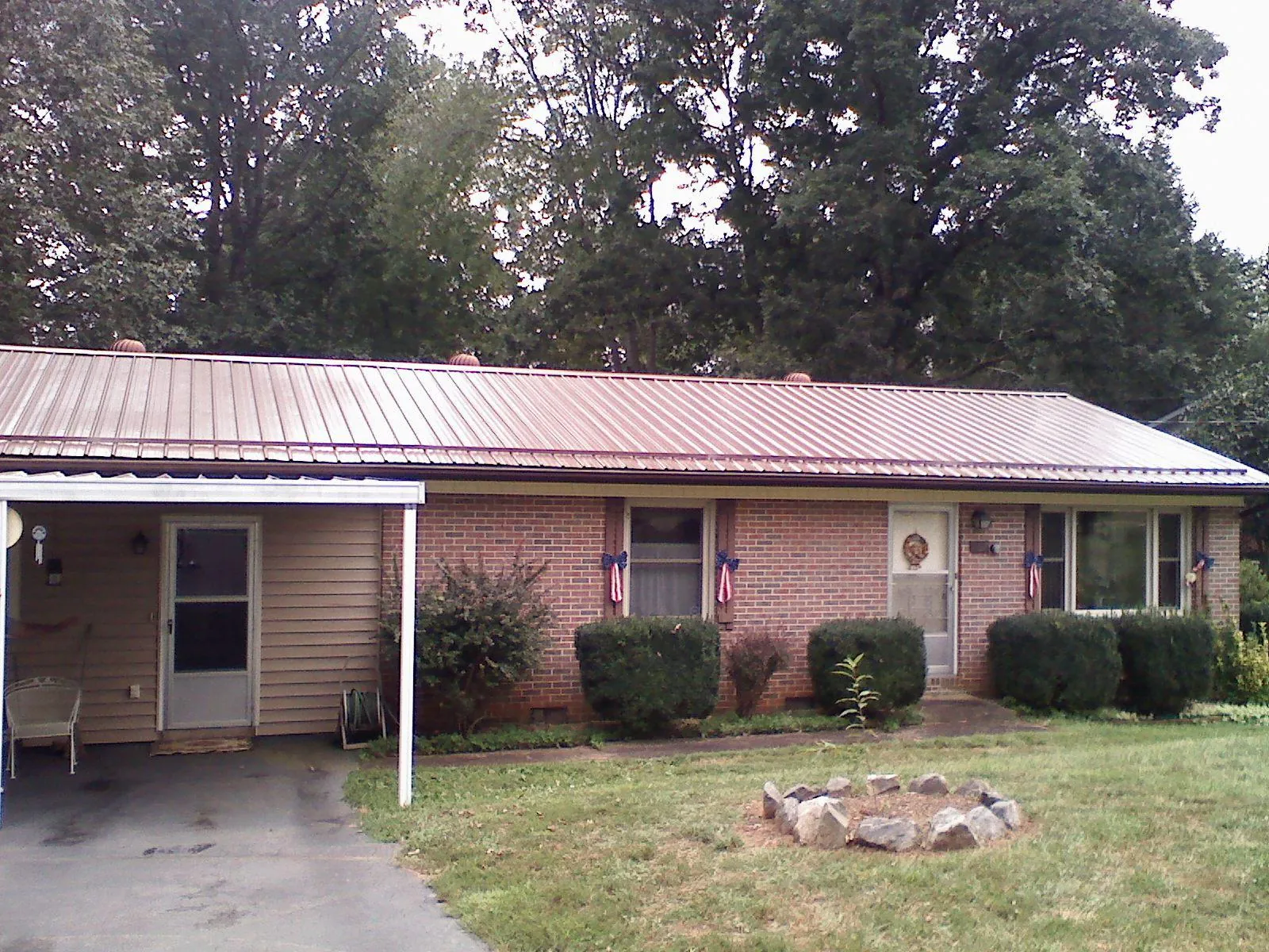 Bronze metal roof and carport on a brick ranch home — Roof Repair work by our crew in Manakin Sabot